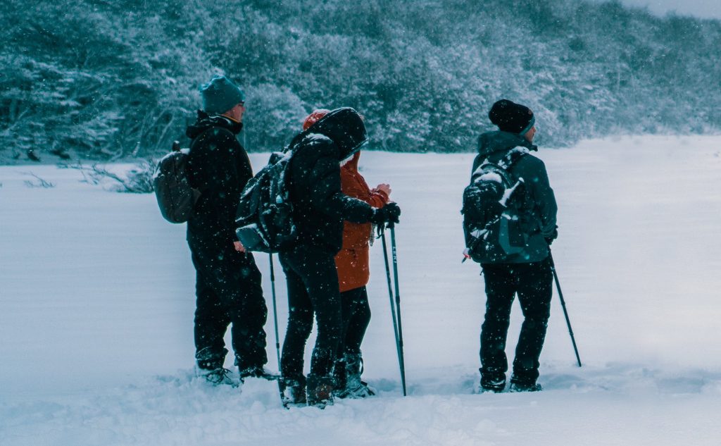 Pratiquants de marche nordique dans la neige équipé de batons et de vêtements spécifiques. 